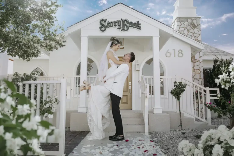 Las Vegas Wedding Groom carrying Bride in front of Storybook Wedding Chapel